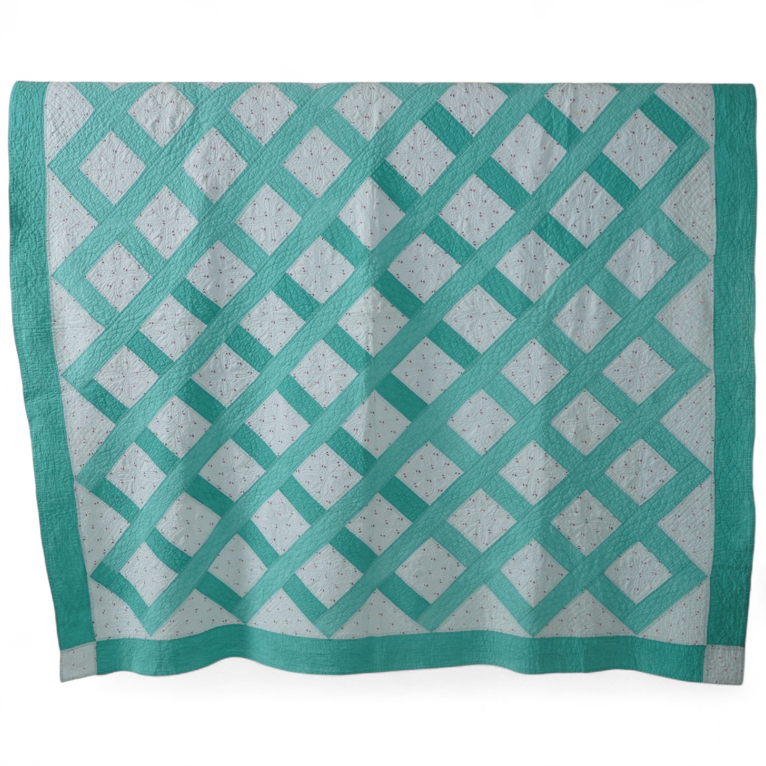 A late 19th early 20th century English, Durham, immaculately hand quilted bedcover. Designed using a plain mint green cotton and a complimentary light floral cotton stripe, in an all over lattice design, with a mint gree